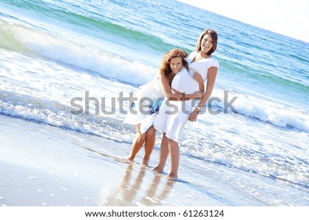 Two sisters on the beach. One of them is embrace