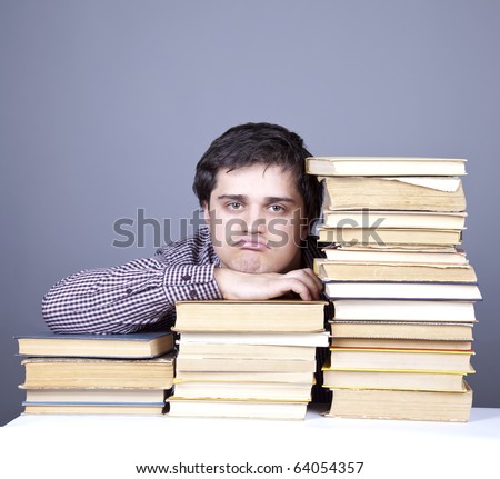 The young sad student with the books isolated. Studio shot.