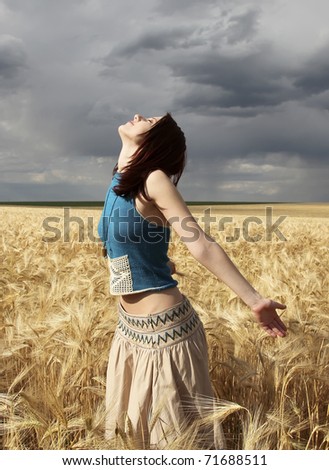 Beautiful girl at wheat field in rainy day. Outdoor photo.