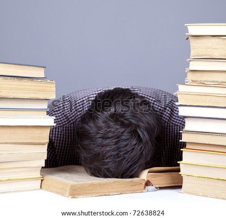 The young tired student with the books isolated. Studio shot.