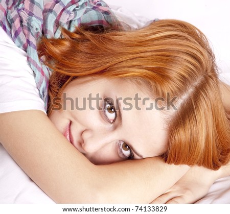 Pretty red-haired sleeping woman in white and scarf lying in the bed