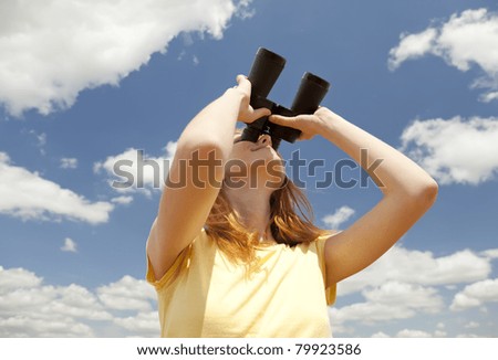 Girl with binocular watching in sky.