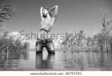 Young and beautiful savage girl in the river. Photo in noisy black and white style.