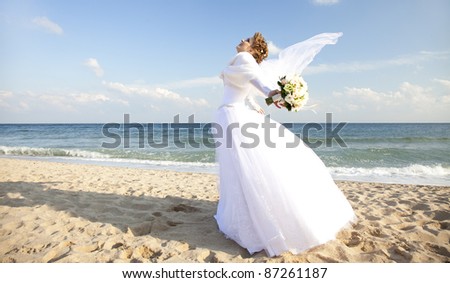 Young bride on the beach with flowers.