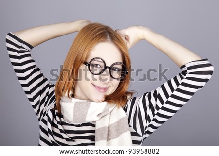 Young red-haired girl in glasses. Studio shot.