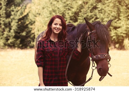 Redhead girl with horse in the forest