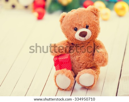 Teddy bear with present on christmas gifts background
