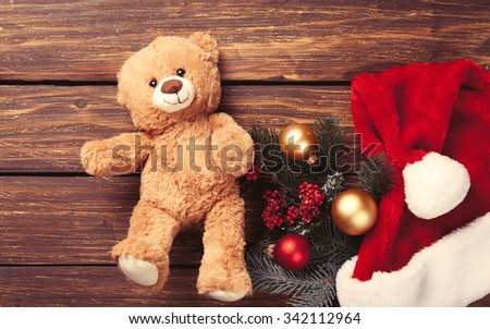 Teddy bear toy and christmas gifts with scarf on red background
