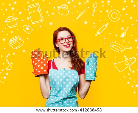 Happy redhead housewife with oven gloves on yellow background
