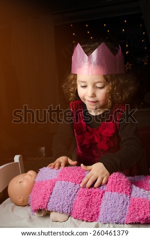 Little girl telling bedtime stories to her doll