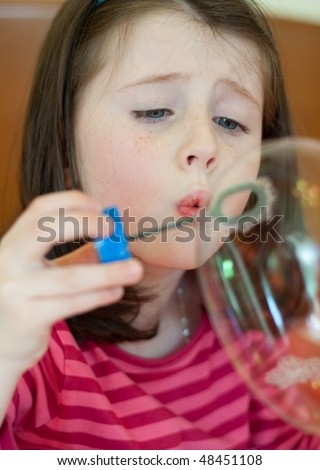 Pretty caucasian girl blows soap bubbles