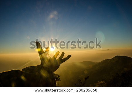Silhouette hand to sun, Sunrise scene with mountain and sea of mist
