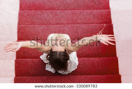 Happy fashion woman profile breathing deep fresh air on stairways with red carpet