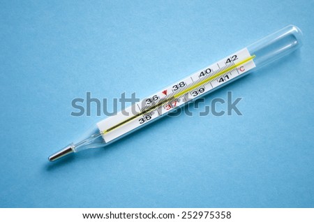 Mercury thermometer shows subfebrile temperature on a blue background.