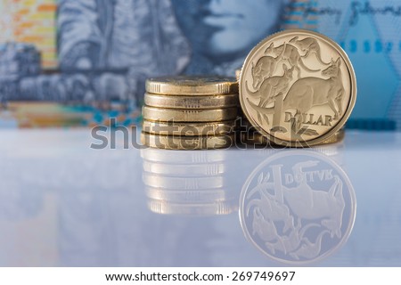 One Dollar Coin with Ten Dollar note in the background - Australian Currency
