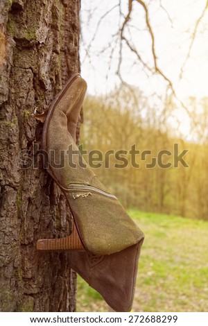 A single woman boots on tree trunk