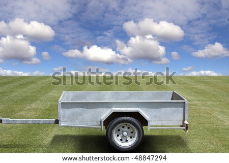 Empty trailer on the green grass and blue sky background