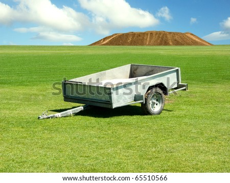 Empty trailer on a green field