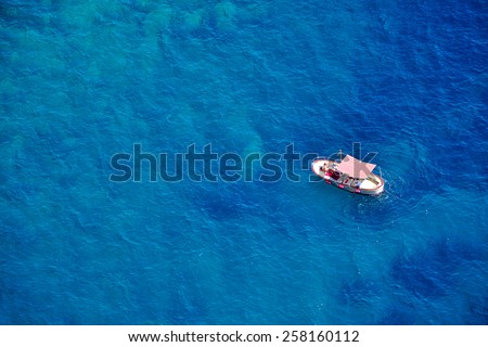 One romantic alone boat in blue sea, bird\'s eyes view, Capri island, Italy