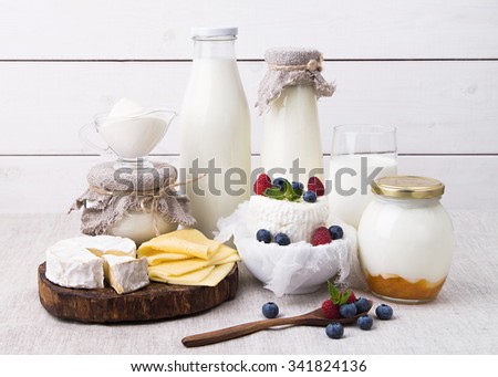 Assorted milk products for breakfast and healthy life - milk, yogurt, cheese, Camembert, home made cream cheese with berries, kefir, sour cream
