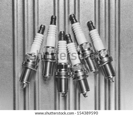 Spark plug for the car on a metal background