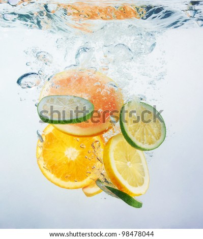 Fresh orange dropped into water with splash isolated on white