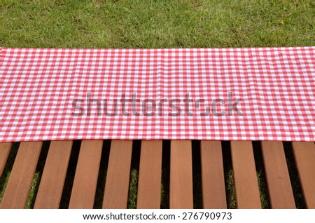 Red and white tablecloth and wooden surface set outdoor