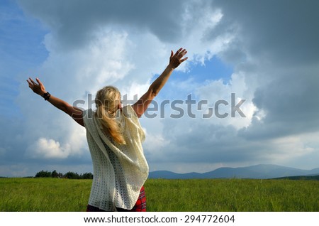 Happy and joyful woman spreading hands to the sky and showing love for nature