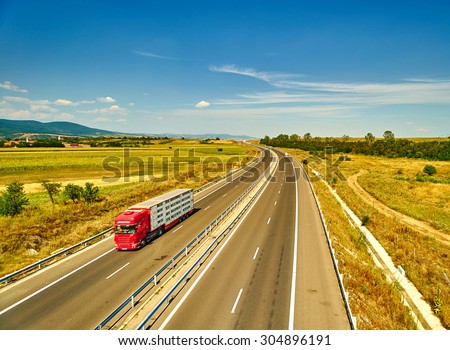 Highway landscape with moving red truck, Romania.