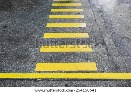 Yellow stripes crosswalk on the old concrete surface
