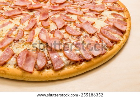 Part of meat pizza with ham and cheese