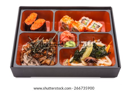 Japanese Meal in a Box (Bento) isolated on white background - Japanese noodles with meat and vegetables, seafood salad, sushi and rolls