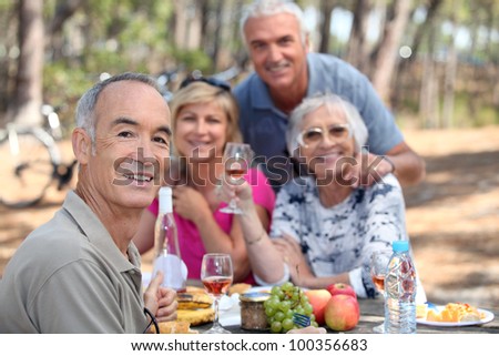 Older people eating in a field
