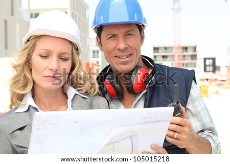 Architect and builder on site with plans