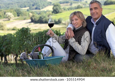 Couple tasting wine in a vineyard