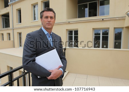 Estate-agent stood outside property