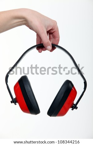 Hand holding a pair of ear defenders
