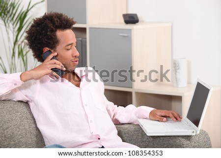 Couple sitting on sofa with computer and phone