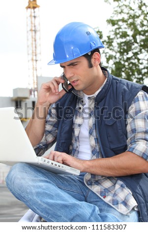 Construction worker with computer and phone