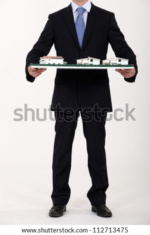 Businessman holding a model of a housing estate