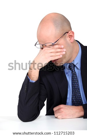 tired businessman rubbing his eyes