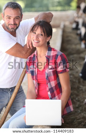 Couple with computer in a farm