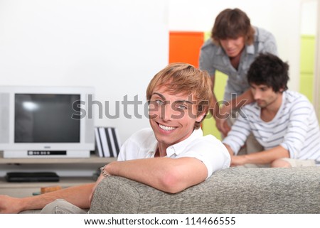 Three young men about to watch television