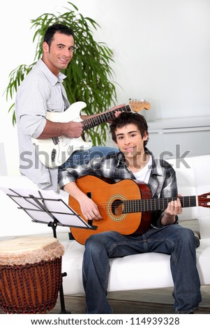 Father teaching son how to play the guitar