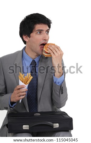 Businessman eating junk food