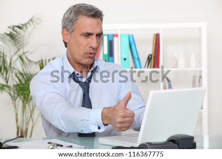 Middle-aged office worker giving thumbs-up