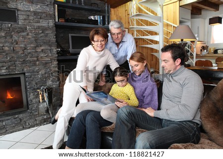 Family reading book on a sofa