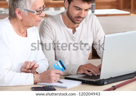 Man helping elderly family member shop on-line