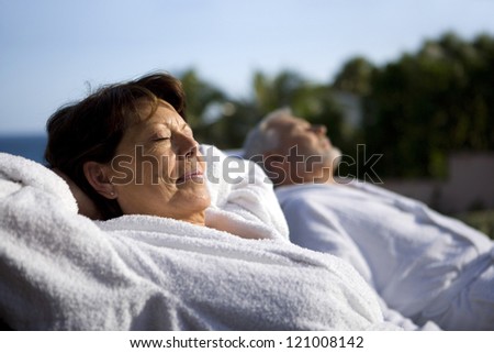 Couple laying outside in bathing robes