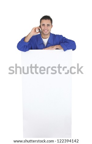 Electrician stood by blank poster surrounded by equipment
